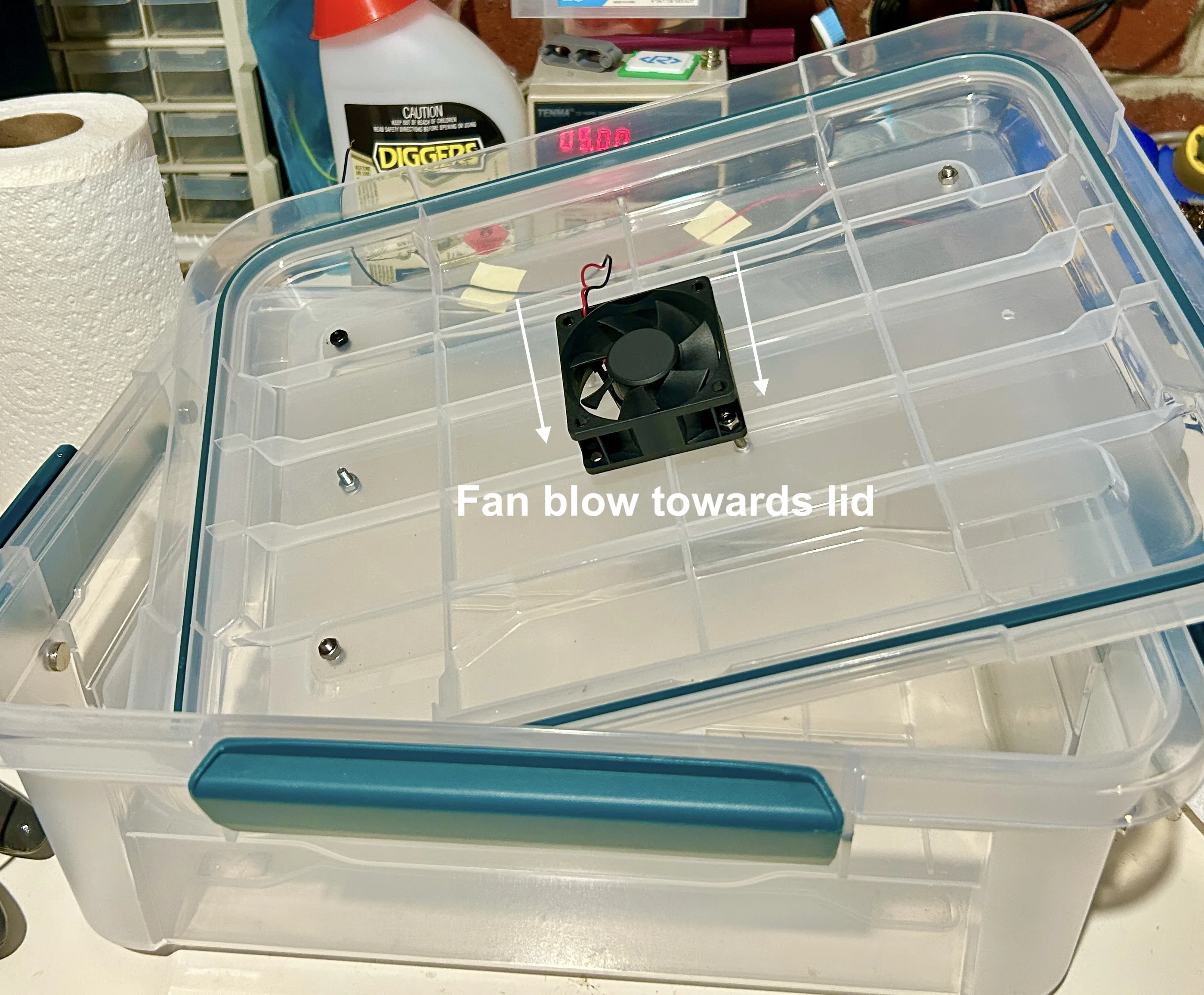 Small fan mounted inside the lid blowing downward toward the base