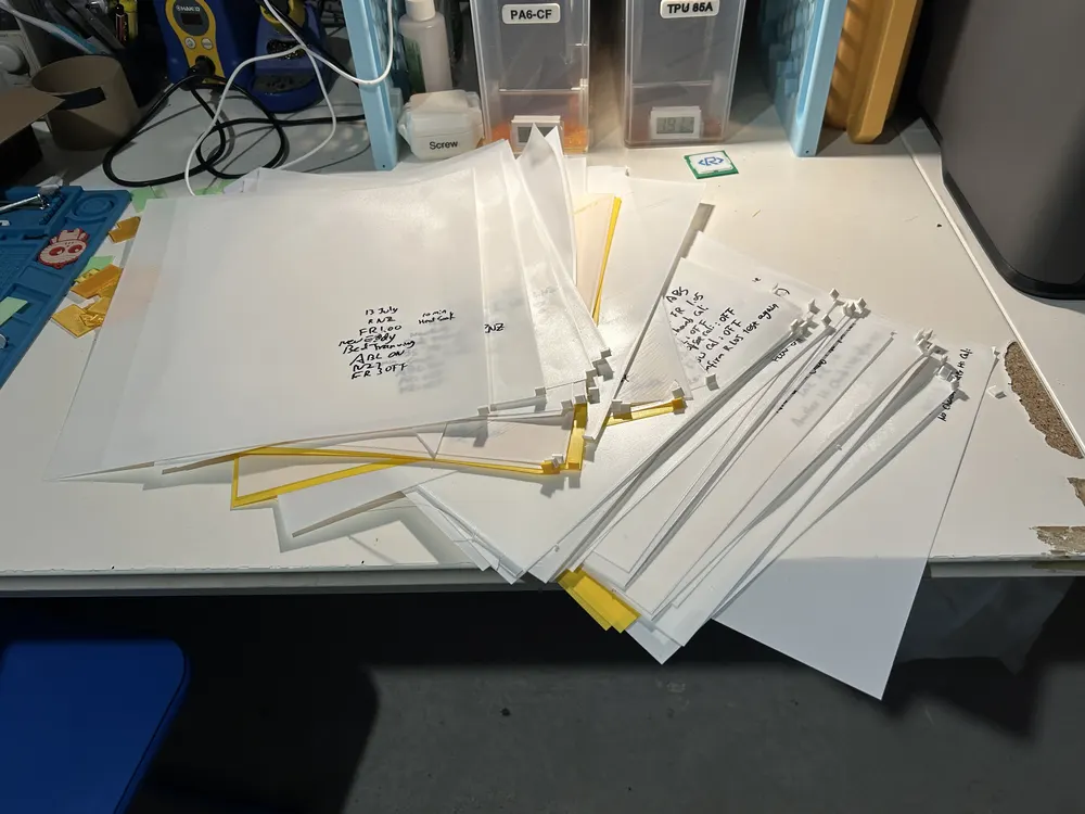 A pile of dozens of handwritten first layer test sheets on the workbench